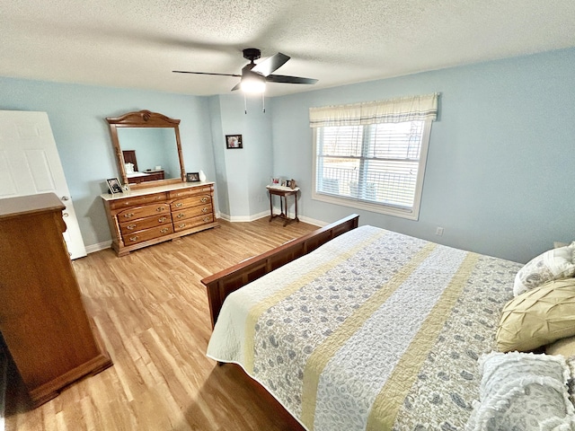 bedroom with ceiling fan, a textured ceiling, and light wood-type flooring