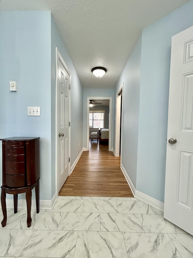 corridor featuring a textured ceiling