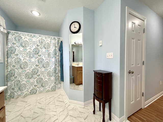 bathroom with a shower with curtain, vanity, and a textured ceiling