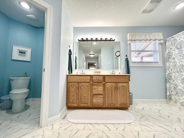 bathroom featuring vanity, a textured ceiling, and toilet