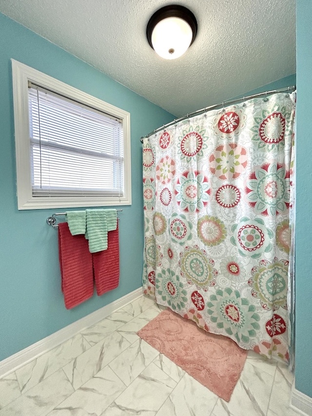 bathroom featuring a shower with curtain and a textured ceiling