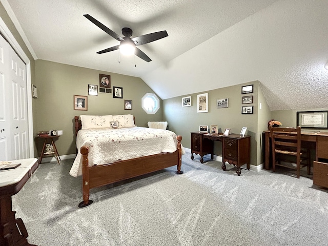 carpeted bedroom featuring vaulted ceiling, ceiling fan, a textured ceiling, and a closet