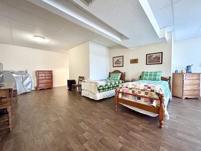 bedroom featuring dark hardwood / wood-style flooring and a paneled ceiling