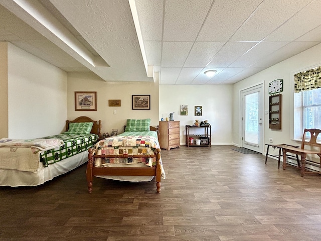 bedroom featuring hardwood / wood-style floors, a paneled ceiling, and access to outside