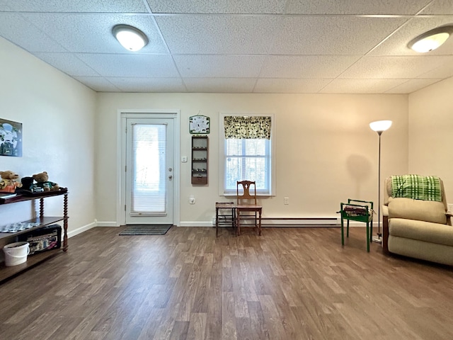 entrance foyer featuring a drop ceiling, hardwood / wood-style floors, and baseboard heating