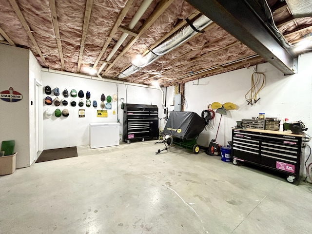 garage with electric panel and a workshop area