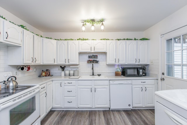 kitchen featuring sink, white appliances, dark wood-type flooring, white cabinetry, and tasteful backsplash