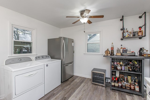 laundry room with ceiling fan, indoor bar, washer and clothes dryer, and light hardwood / wood-style flooring