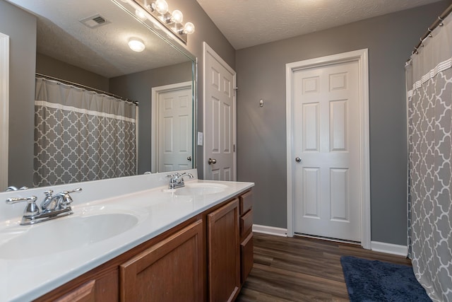 bathroom with vanity, hardwood / wood-style flooring, and a textured ceiling