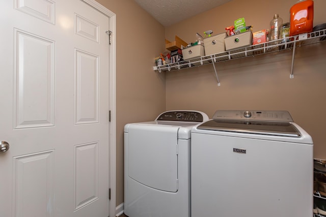 laundry room with a textured ceiling and independent washer and dryer