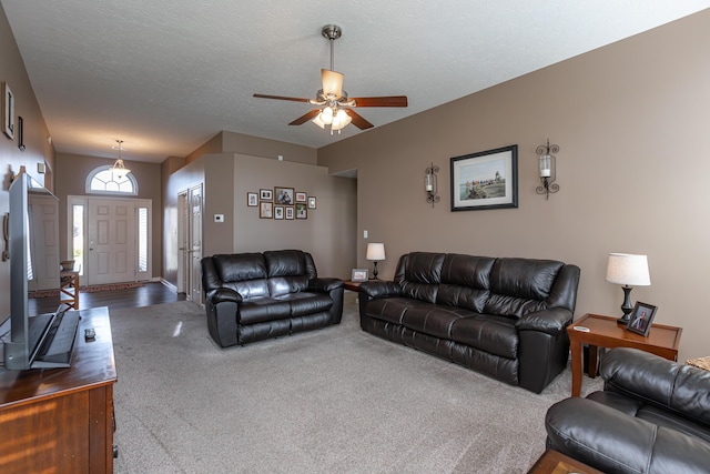 living room with ceiling fan, carpet, and a textured ceiling