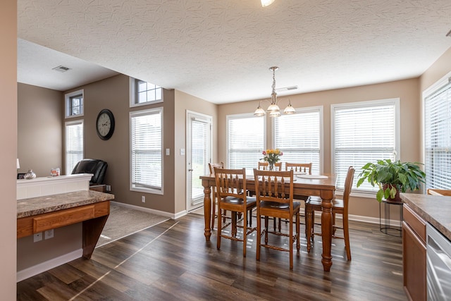 dining space featuring a chandelier, a textured ceiling, and dark hardwood / wood-style flooring