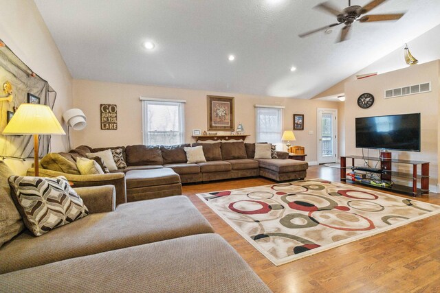 living room with light hardwood / wood-style flooring, high vaulted ceiling, and ceiling fan