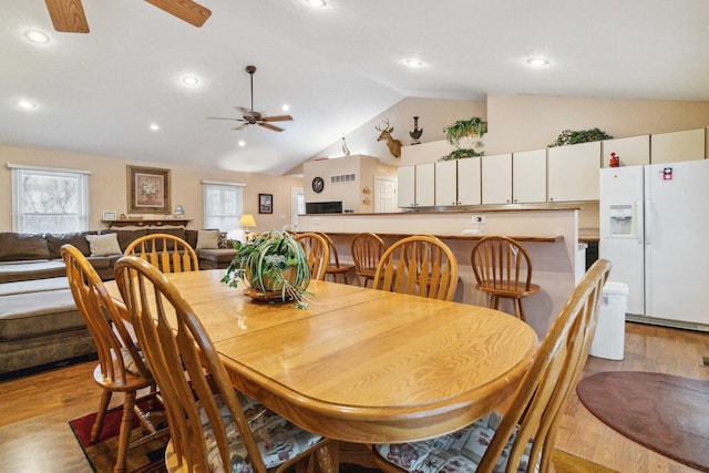 dining room featuring ceiling fan, lofted ceiling, and light hardwood / wood-style floors