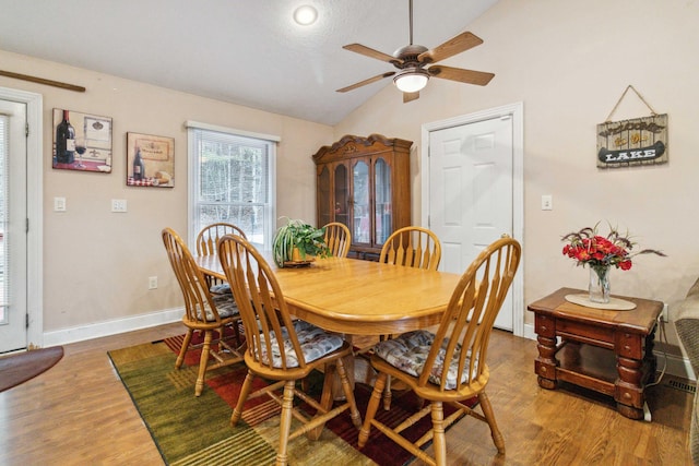 dining room featuring lofted ceiling, wood-type flooring, and ceiling fan