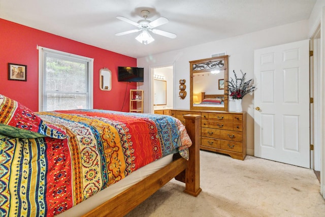 carpeted bedroom with ceiling fan and ensuite bath