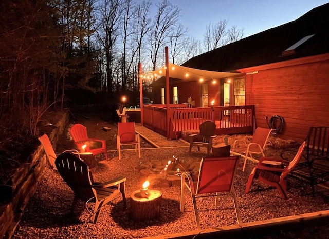 deck at dusk featuring an outdoor fire pit