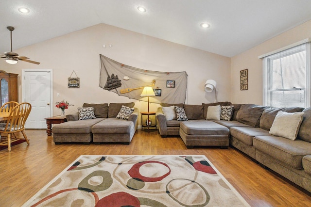 living room featuring vaulted ceiling, ceiling fan, and light hardwood / wood-style flooring