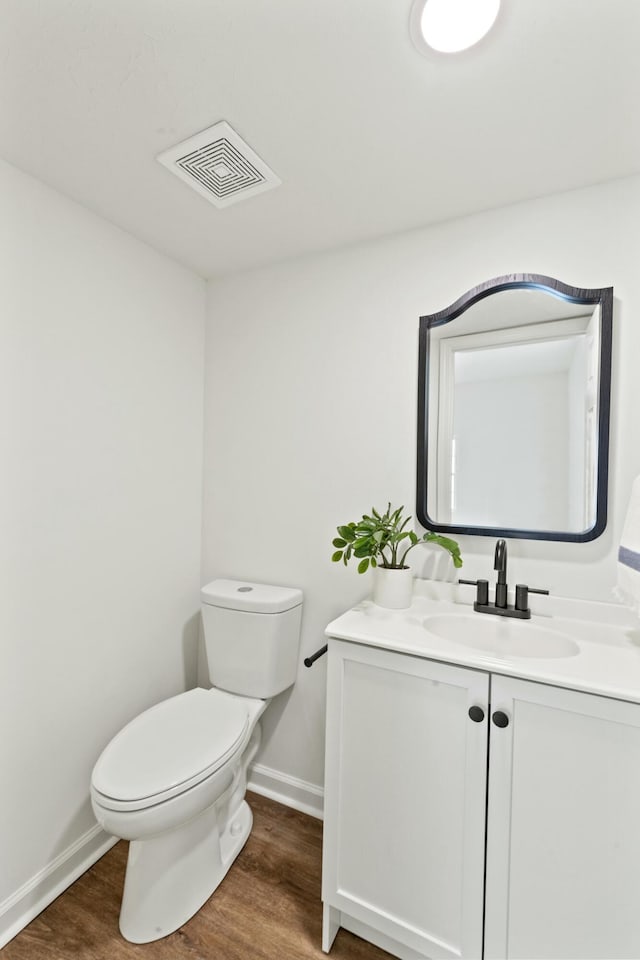 bathroom with vanity, hardwood / wood-style flooring, and toilet