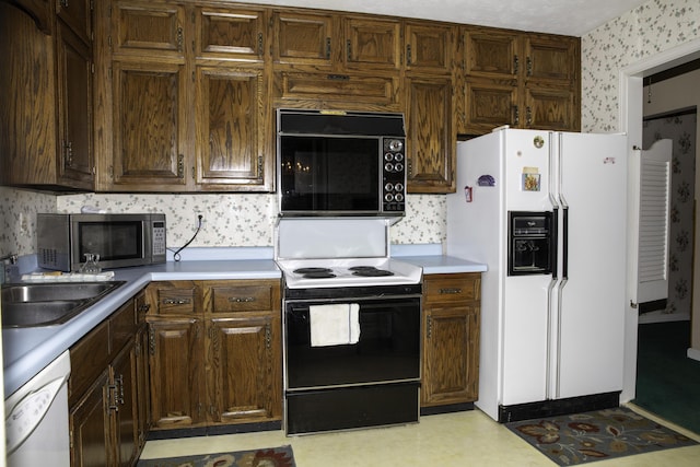 kitchen featuring dark brown cabinets, sink, and white appliances