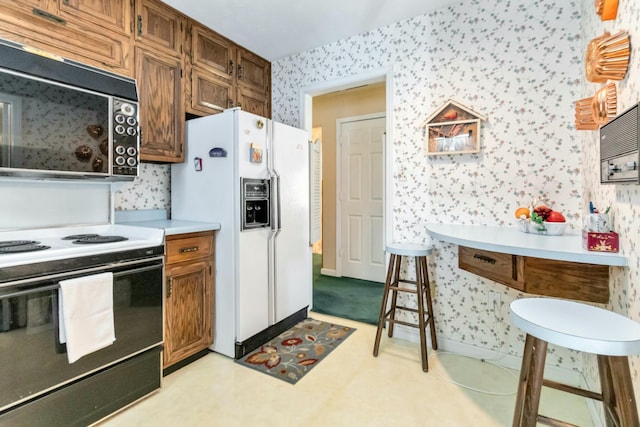 125 Thomas St, Somerset, KY 42503 - kitchen with wallpapered walls, light countertops, electric stove, black microwave, and white fridge with ice dispenser