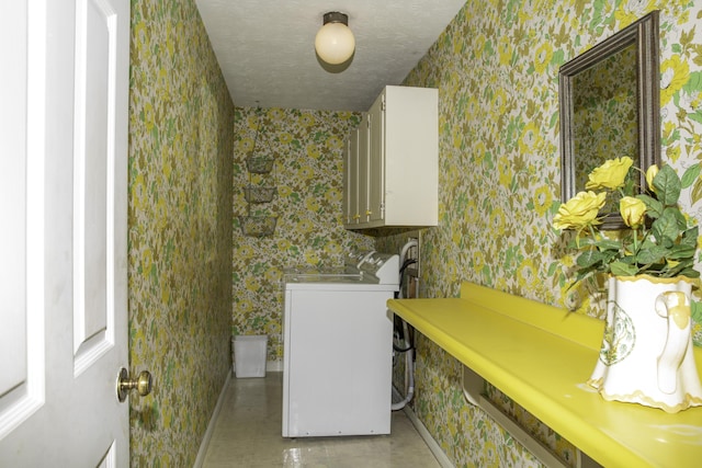 laundry area featuring cabinets, washer / dryer, and a textured ceiling