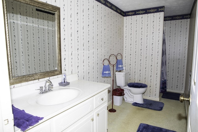 bathroom featuring vanity, a textured ceiling, and toilet