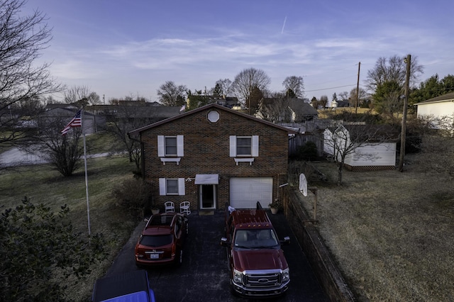 view of front of property with a garage and a yard