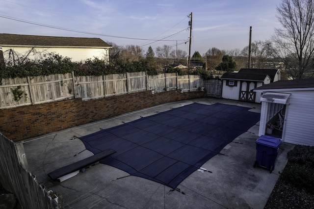 view of swimming pool with a patio area and a storage unit