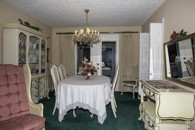 dining area featuring dark carpet, a textured ceiling, and a chandelier