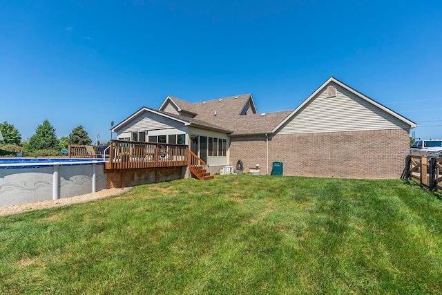 rear view of house featuring a swimming pool side deck and a yard