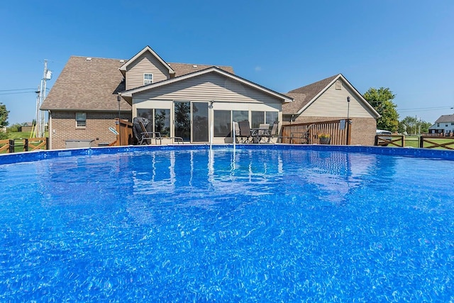 view of swimming pool featuring a sunroom