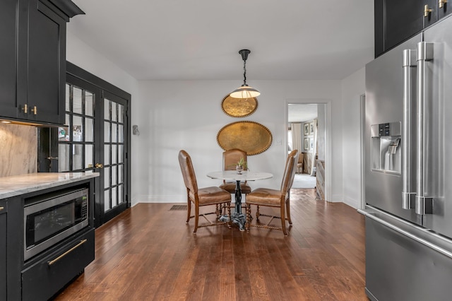 dining space with dark wood finished floors and baseboards