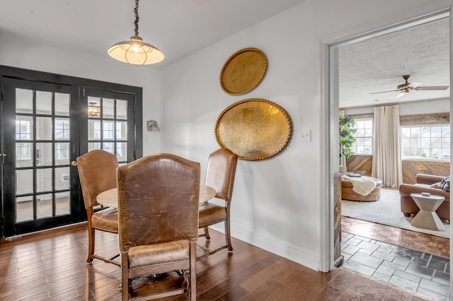 dining area featuring ceiling fan, baseboards, and wood finished floors