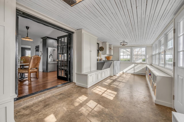 unfurnished sunroom featuring wood ceiling and a sink