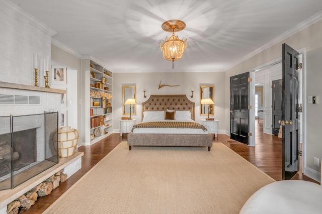 bedroom featuring crown molding, a fireplace, baseboards, dark wood-style floors, and an inviting chandelier