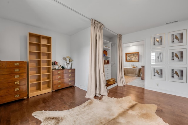 bedroom with visible vents, baseboards, and wood finished floors