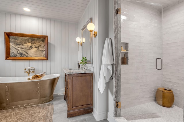 bathroom with a stall shower, a soaking tub, and vanity