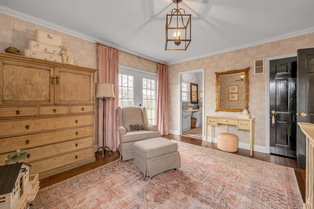 living area with wallpapered walls, baseboards, visible vents, ornamental molding, and wood finished floors