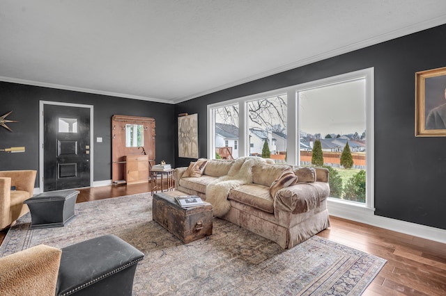 living area with crown molding, wood finished floors, and baseboards