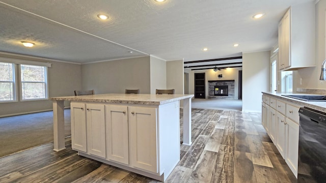 kitchen featuring a center island, a kitchen bar, black dishwasher, and white cabinets