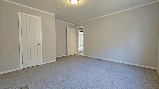 carpeted spare room featuring crown molding and a textured ceiling