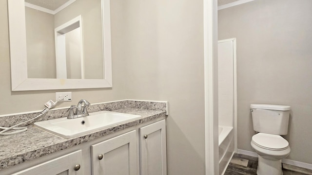 bathroom with vanity, crown molding, toilet, and hardwood / wood-style flooring