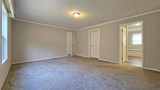 unfurnished bedroom featuring light colored carpet, ensuite bath, ornamental molding, and a textured ceiling