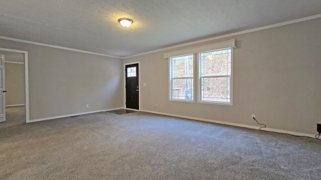 unfurnished room with crown molding, carpet, and a textured ceiling