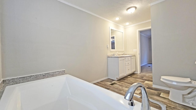 bathroom featuring hardwood / wood-style flooring, a bathing tub, vanity, ornamental molding, and toilet