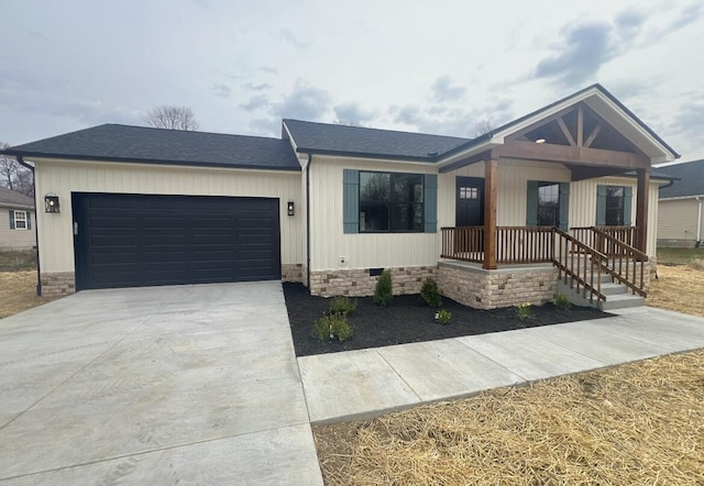 view of front facade featuring roof with shingles, covered porch, driveway, crawl space, and an attached garage