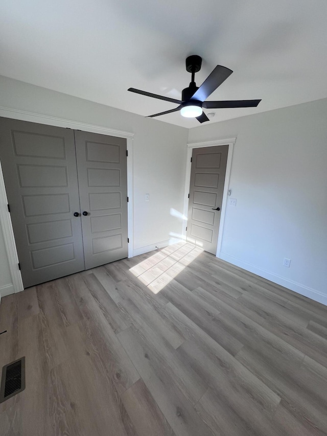 unfurnished bedroom with ceiling fan, light hardwood / wood-style floors, and a closet