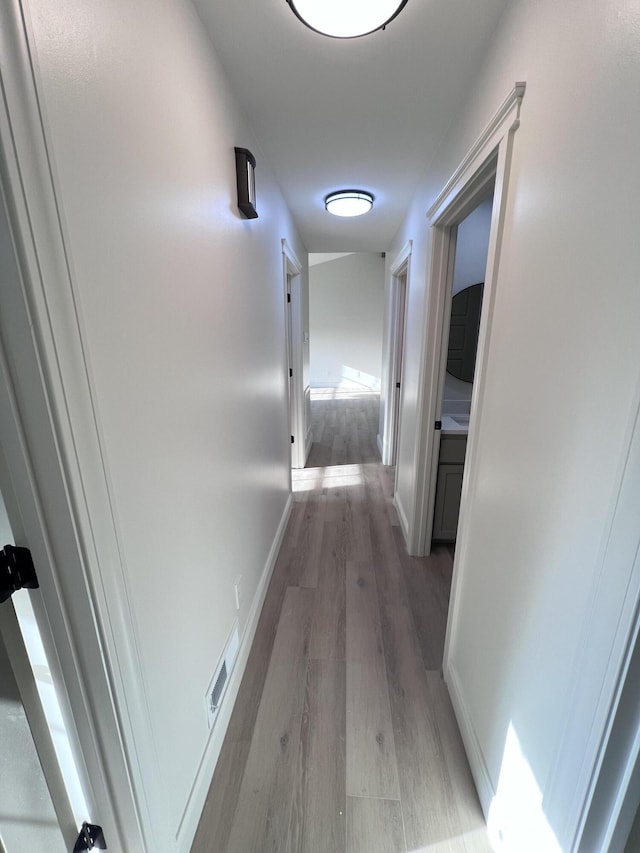 hall featuring baseboards and light wood-style floors