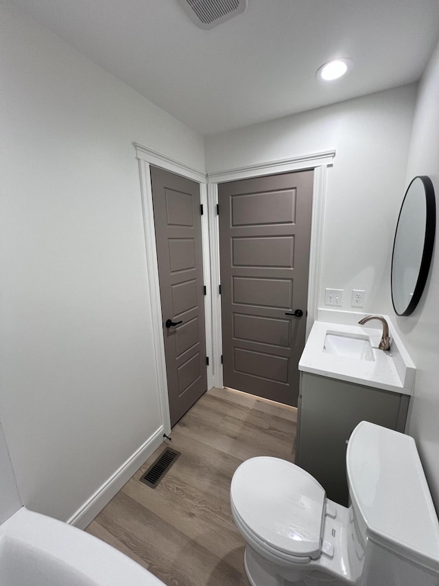 bathroom featuring vanity, hardwood / wood-style floors, and toilet